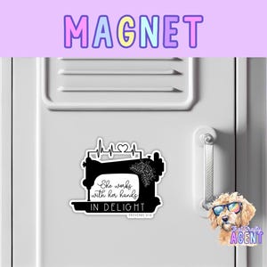 May include: Black and white magnet featuring a sewing machine with a heart and the text "She works with her hands in delight, Proverbs 31:15".