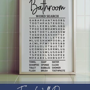 May include: A white framed print with a black and white word search puzzle titled "Bathroom Word Search". The puzzle includes words related to bathroom items such as "towel", "soap", "water", "shampoo", "sponge", "clean", "toilet", "bubbles", "shower", "flush", "brush", and "toothpaste". The print also includes the text "Fun Wall Decor for the Bathroom".