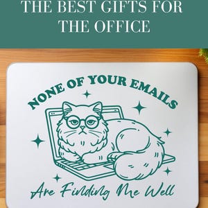 Op de afbeelding: Een witte laptop sticker met een groene omtrek van een kat met een bril die op een laptop zit. De tekst op de sticker luidt "Geen van je e-mails vindt me goed".