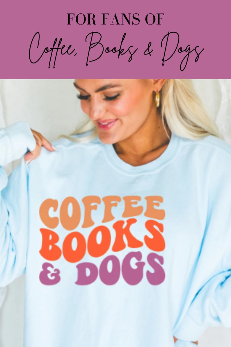 May include: A light blue sweatshirt with the text "COFFEE BOOKS & DOGS" in a retro font. The text is in shades of orange, red, and purple.