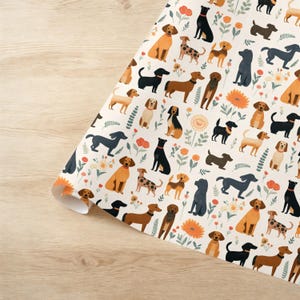 May include: A white background with a repeating pattern of dogs in various breeds and colors. The dogs are surrounded by small green leaves and orange flowers.