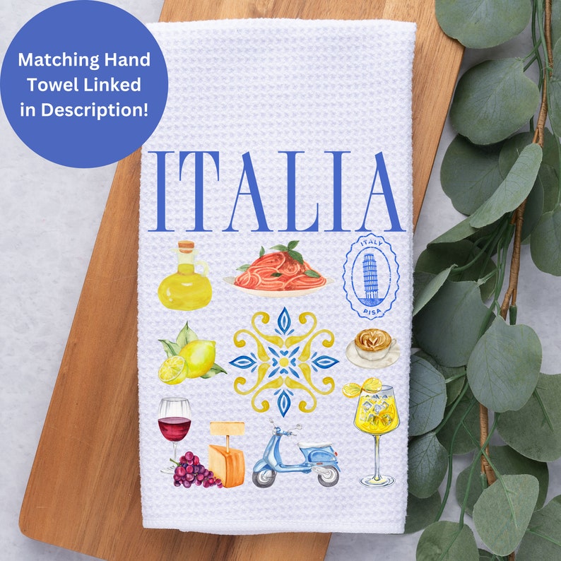 K&ouml;nnte beinhalten: Wei&szlig;es Waffel-K&uuml;chentuch mit dem Wort "ITALIA" in Blau. Das Handtuch zeigt Aquarellillustrationen italienischer Speisen und Sehensw&uuml;rdigkeiten, darunter Pasta, Zitronen und einen Roller. Ein blauer Kreis oben links sagt "Passendes Handtuch in der Beschreibung verlinkt!"