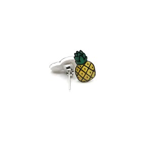 May include: A pair of silver stud earrings with a yellow pineapple design. The pineapple is outlined in black and has a green top.