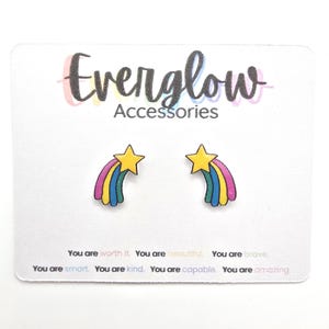May include: Earrings featuring a yellow star and a rainbow design in pink, blue, and green, presented on a white card. The card is printed with the text "Everglow Accessories" and motivational phrases.