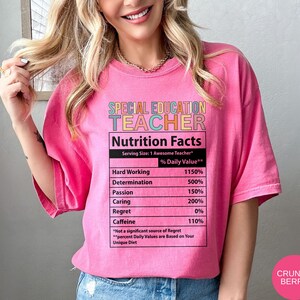 Op de afbeelding: Roze T-shirt met een afbeelding van een voedingsschema-etiket met de tekst "Special Education Teacher". Het etiket somt "Hard Working", "Determination", "Passion", "Caring", "Regret" en "Caffeine" op met percentages naast elk item.