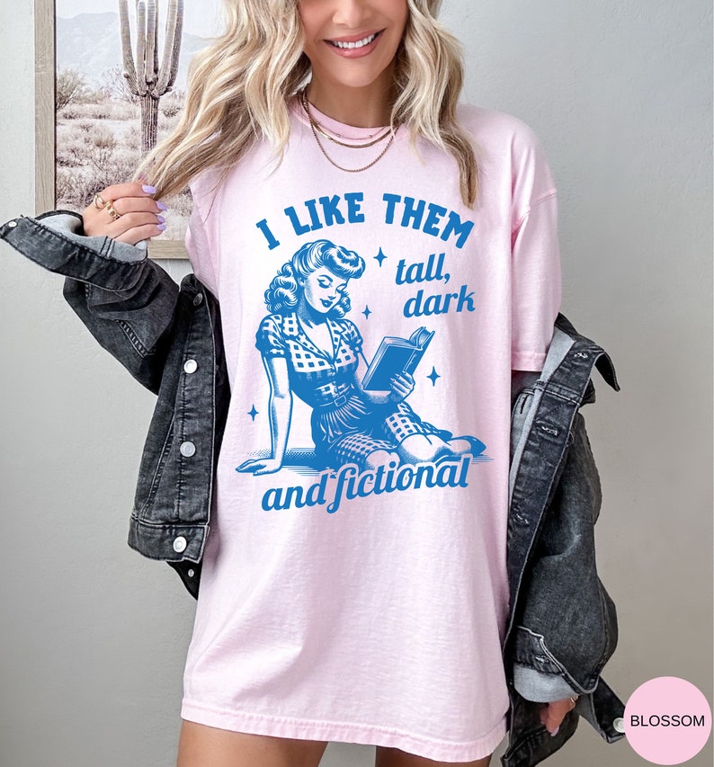A model wears a blossom shirt that has a retro design all in medium blue that days I like them tall, dark and fictional, with a woman from the 1950s sittings and reading a book.
