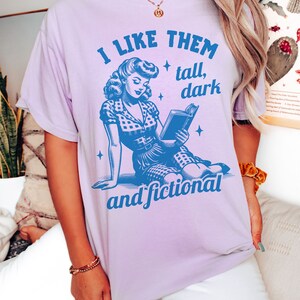 A model wears an orchid shirt that has a retro design all in medium blue that days I like them tall, dark and fictional, with a woman from the 1950s sittings and reading a book.