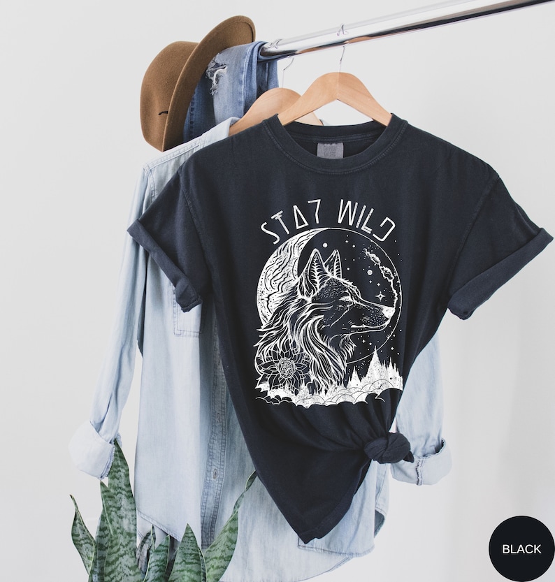 May include: Black t-shirt with a white wolf howling at the moon graphic and the text "Stay Wild".