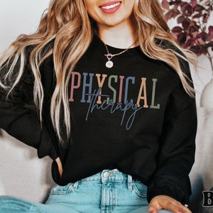 May include: A black sweatshirt with the text "PHYSICAL therapy" in colorful letters. The text is in a modern font style.