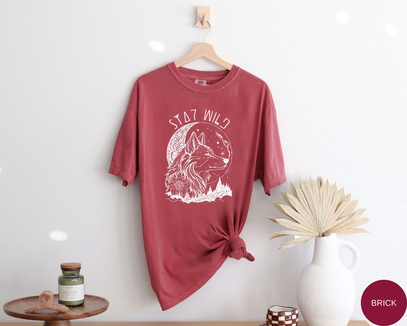 May include: A red t-shirt with a white wolf graphic and the text "Stay Wild".