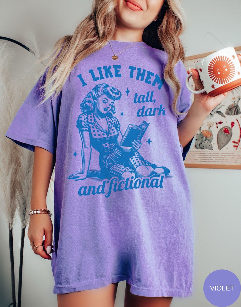 A model wears a violet shirt that has a retro design all in medium blue that days I like them tall, dark and fictional, with a woman from the 1950s sittings and reading a book.