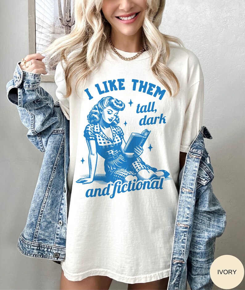 A model wears an ivory shirt that has a retro design all in medium blue that days I like them tall, dark and fictional, with a woman from the 1950s sittings and reading a book.