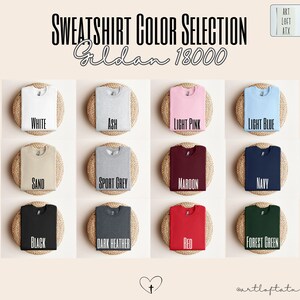 May include: A selection of Gildan 18000 sweatshirts in various colors, including white, ash, light pink, light blue, sand, sport grey, maroon, navy, black, dark heather, red, and forest green.