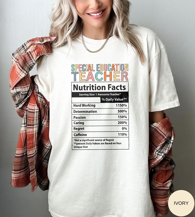 Op de afbeelding: Wit T-shirt met een kleurrijke afbeelding met de tekst "Special Education Teacher" en een voedingsschema met percentages voor hard werken, vastberadenheid, passie, zorg, spijt en cafe&iuml;ne. De tekst onderaan het schema luidt "*Geen significante bron van spijt **Procentuele dagelijkse waarden zijn gebaseerd op uw unieke dieet"