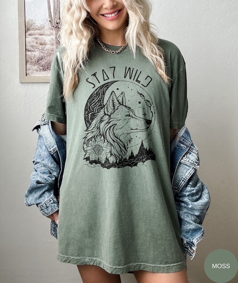 May include: A green t-shirt with a wolf howling at the moon graphic and the text "Stay Wild".