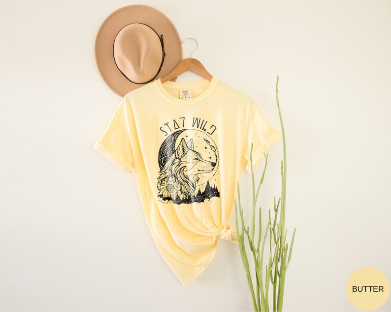 May include: A yellow t-shirt with a black wolf graphic and the text "Stay Wild".