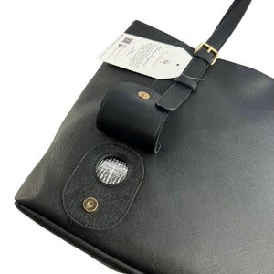 Peut inclure: Sac fourre-tout noir avec une boucle dor&eacute;e et une petite poche noire attach&eacute;e &agrave; la bandouli&egrave;re. Le sac a une ouverture circulaire avec une doublure argent&eacute;e et un bouton dor&eacute;.