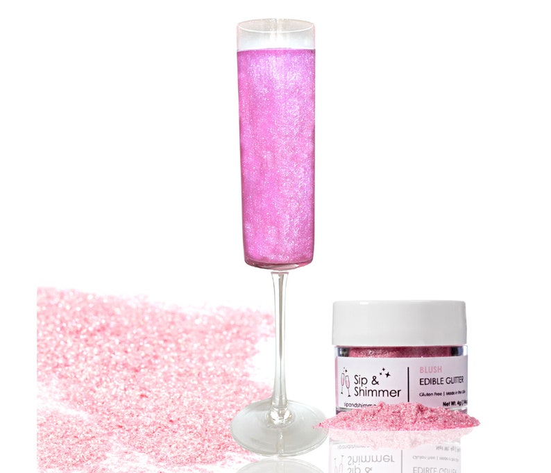 May include: A small jar of pink edible glitter labeled "Sip & Shimmer Blush Edible Glitter". The glitter is shown in a champagne flute and scattered on a white surface.