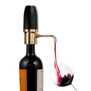 Puede incluir: Un aireador y vertedor de vino negro y dorado está conectado a una botella de vino, con vino tinto vertiéndose en una copa. El aireador tiene un diseño elegante y moderno, realzando el sabor del vino.