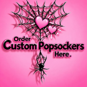 May include: A bright pink graphic featuring a black spider web shaped like a heart with two pink hearts inside. A black spider hangs from the web. The text reads Order Custom Popsockers Here in black letters with a pink outline on a pink background.