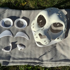 Op de afbeelding: Witte, onafgewerkte harige masker met aparte witte kunststof ogen, neus, tanden en wenkbrauwen. Het masker is gemaakt voor een harige kostuum.