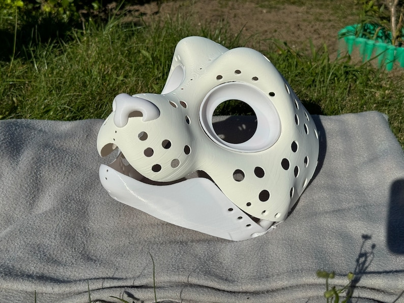 Op de afbeelding: Witte, onafgewerkte vachtdiermasker met een groot ooggat en een kleine neus. Het masker is gemaakt van een lichtgewicht materiaal en heeft een textuur.