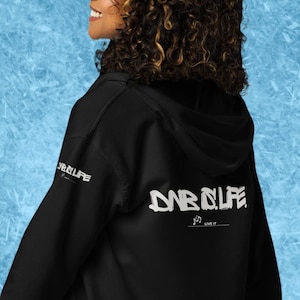 Puede incluir: Sudadera negra con cremallera y capucha, con un gráfico blanco en la espalda que dice "DAB IS LIFE" y un gráfico más pequeño en la manga izquierda que dice "DAB IS LIFE".