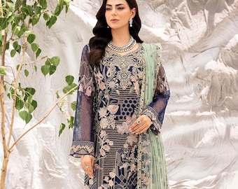 Puede incluir: Un vestido de color azul marino y rosa con estampado floral y bordados intrincados. El vestido tiene mangas largas y un pantalón a juego. El conjunto se completa con una dupatta transparente de color verde claro.