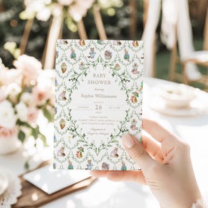 Könnte beinhalten: Eine Babyparty-Einladung mit einem skurrilen Design, das Illustrationen von Tieren und floralen Elementen zeigt. Die Einladung enthält den Text "Baby Shower" sowie Details zur Veranstaltung, einschließlich Name, Datum, Uhrzeit und Ort.