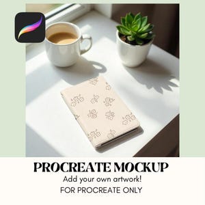 May include: A white notebook with a floral pattern on the cover. The notebook is sitting on a white surface with a cup of coffee and a potted succulent plant.