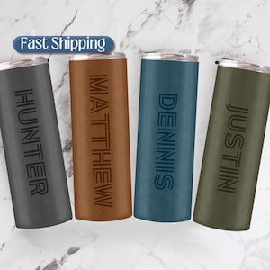 May include: Four stainless steel tumblers with different names engraved on them. The tumblers are in the colors gray, brown, blue, and green.