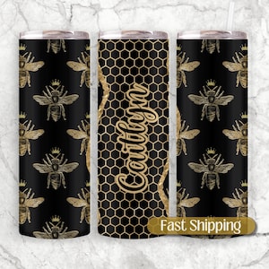 May include: Three stainless steel tumblers with a black and gold honeycomb pattern and gold bee illustrations. The middle tumbler has the word "Southern" written in gold script.