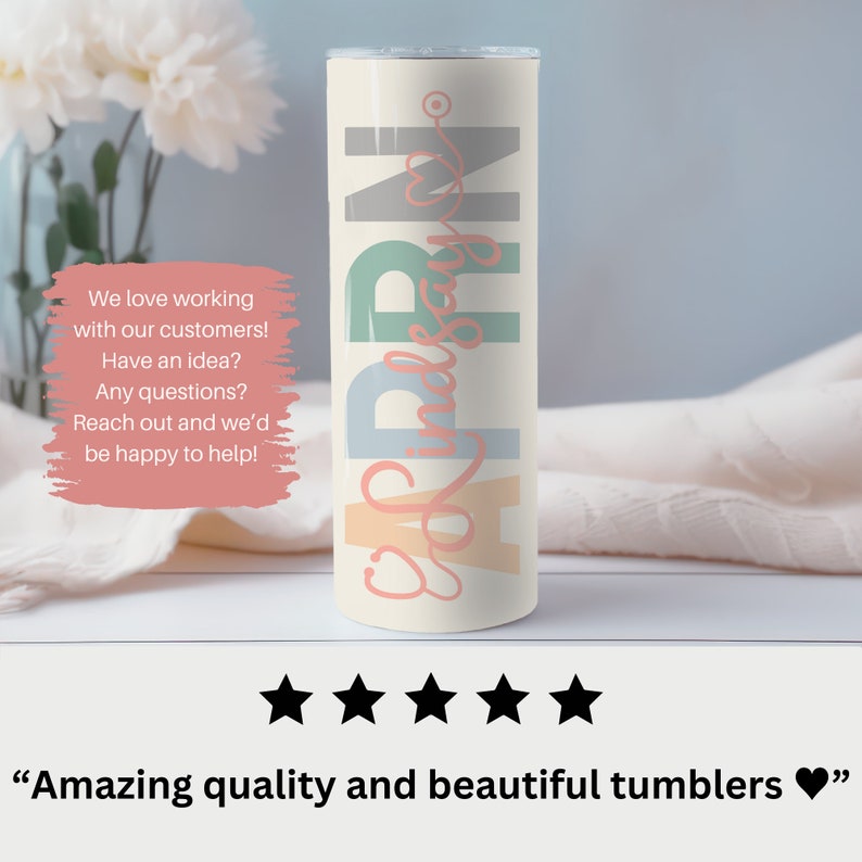 May include: A white tumbler with a colorful design that says "PR.N" in a cursive font. The tumbler is on a white surface with a white blanket in the background.
