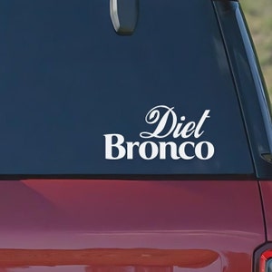 Puede incluir: Calcomanía de vinilo blanco con el texto "Diet Bronco" en un coche rojo.