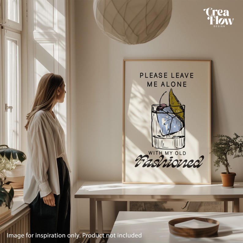 K&ouml;nnte beinhalten: Ein gerahmter Druck mit dem Text "PLEASE LEAVE ME ALONE WITH MY OLD FASHIONED" und einer Cocktail-Illustration. Das Kunstwerk hat einen beigen Hintergrund und ein minimalistisches Design, geeignet f&uuml;r die Inneneinrichtung.