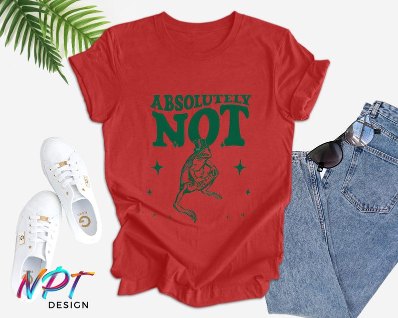 Puede incluir: Camiseta roja con un gr&aacute;fico de rana verde y el texto "ABSOLUTELY NOT" en letras verdes.
