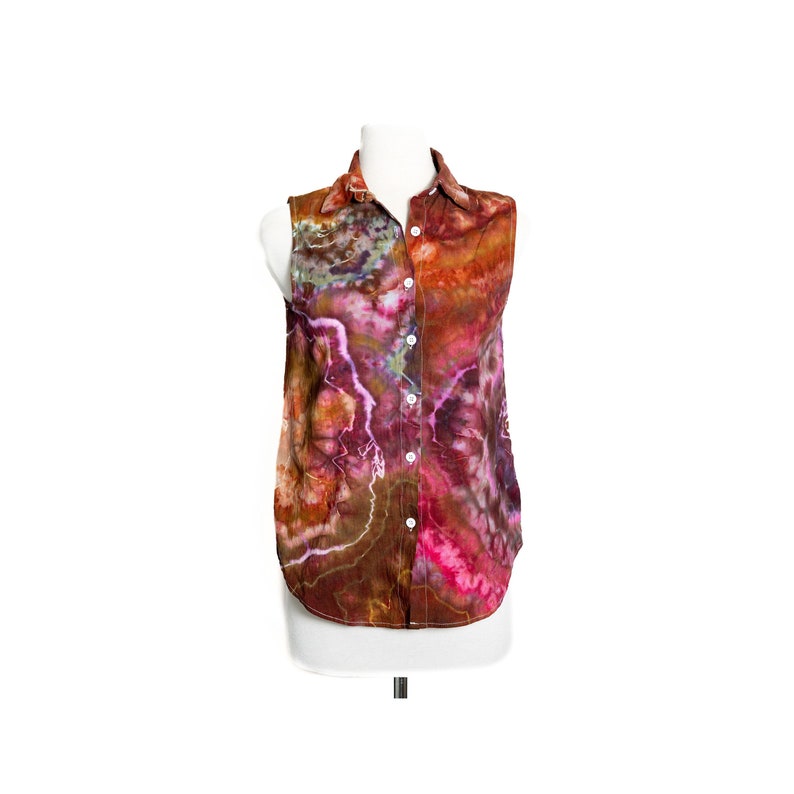 May include: A sleeveless button-up shirt with a tie-dye pattern in shades of brown, pink, and purple.