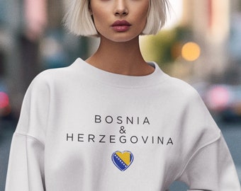 Könnte beinhalten: Weißer Pullover mit dem Text "BOSNIA & HERZEGOVINA" und einer herzförmigen bosnischen Flagge.