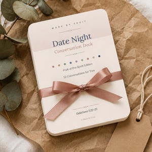 Può includere: Un mazzo di carte rettangolare intitolato Date Night Conversation Deck, Fruit of the Spirit Edition, 52 Conversations for Two, Galatians 5:22-23, Mark By Fruit. Il mazzo è legato con un nastro di raso rosa polvere su uno sfondo color crema.
