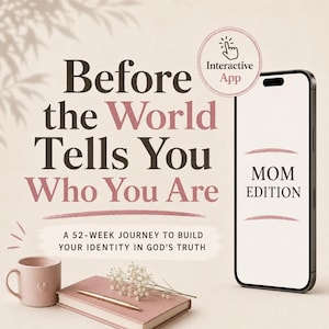 May include: A smartphone displaying 'MOM EDITION' text, next to a pink mug, a closed pink notebook with a gold pen, and a sprig of baby's breath. The text reads 'Before the World Tells You Who You Are' and 'A 52-WEEK JOURNEY TO BUILD YOUR IDENTITY IN GOD'S TRUTH'.