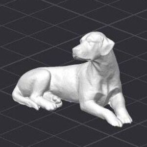 May include: A white ceramic sculpture of a dog lying down. The dog is looking to the right and has its head tilted slightly. The sculpture is detailed and realistic.