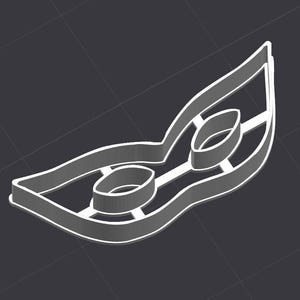 May include: A white plastic cookie cutter shaped like a masquerade mask with two eye holes.