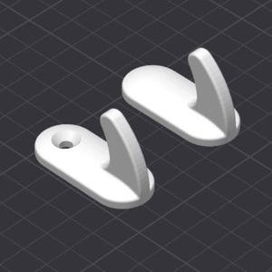 May include: Two white, plastic wall hooks. Each hook has a flat, oval base with a curved hook extending upwards. One hook has a small hole for mounting. The hooks are set against a dark gray, grid-patterned background.