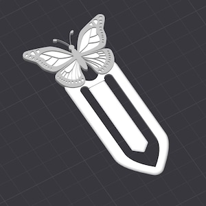 May include: White metal bookmark with a butterfly design. The butterfly has intricate details and is attached to a metal bookmark.