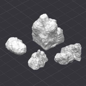 May include: Four white, textured rock formations of varying sizes are arranged on a dark gray grid background. The rocks have a rough, uneven surface, suggesting a natural, weathered appearance. The arrangement is likely for decorative or artistic purposes.