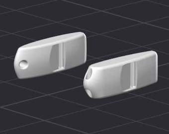 May include: Two white, oblong-shaped objects with a rounded end and a hole. Each object has a rectangular cutout and a groove. The objects are set against a dark, grid-patterned background.