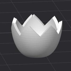 May include: A white ceramic egg-shaped bowl with a decorative, cracked, flower-like opening.