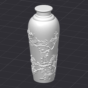 May include: A white, cylindrical vase with a detailed relief design of flowering branches and birds. The vase has a rounded top and a slightly flared base. The relief pattern is visible on the surface.