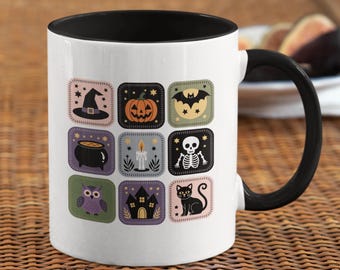 May include: White ceramic mug with a black interior and handle. The mug features a Halloween-themed design with various square illustrations including a witch's hat, pumpkin, bat, cauldron, candle, skeleton, owl, haunted house, and black cat.