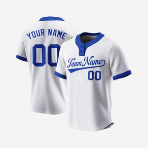 Könnte beinhalten: Weißes Baseballtrikot mit blauen Besätzen und einem blauen Teamnamen und einer blauen Nummer auf der Vorderseite. Die Rückseite des Trikots hat einen blauen Namen und eine blaue Nummer.